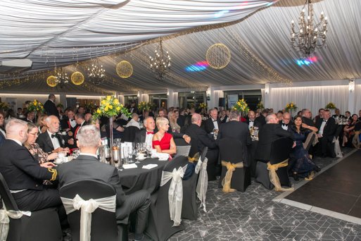 Attendee's of the 2024 Boots and Beret awards, sit for a formal reception and dinner, in a stylishly decorated gala tent.